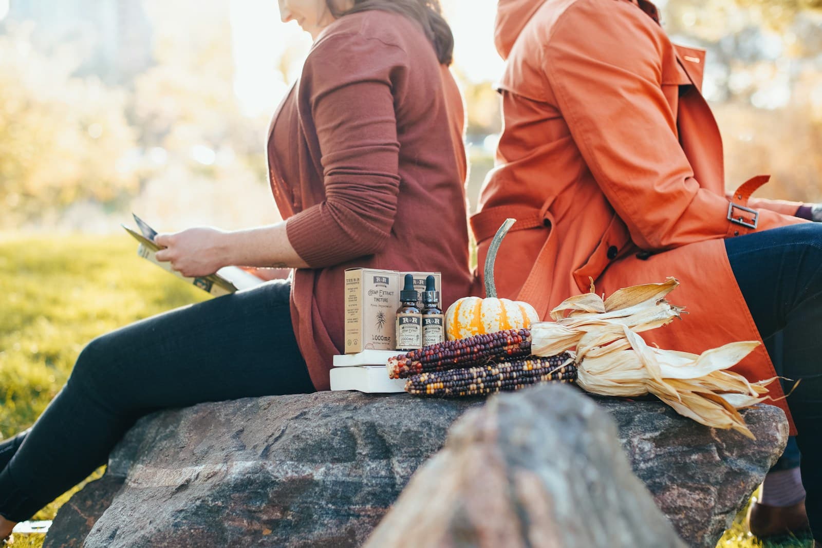 Photo by R+R Medicinals woman wearing orange coat beside woman wearing black leggings